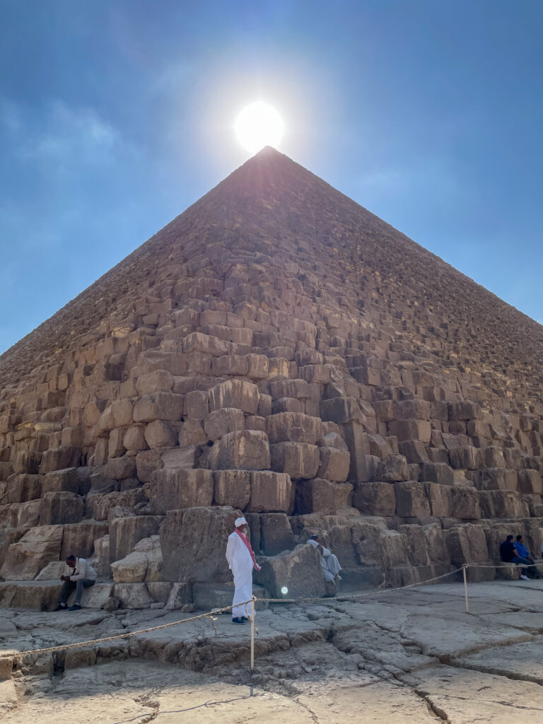 a man stands in front of the great pyramid of khufu